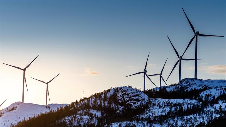 Vindmøller på snødekte fjell.