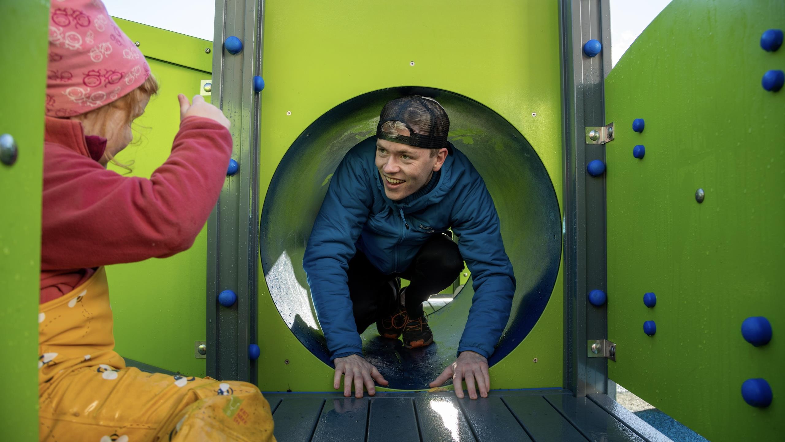 A child and a kindergarten teacher playing in a play stand.