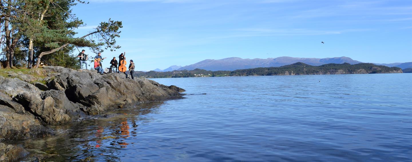 Studenter med instrumenter ved fjorden