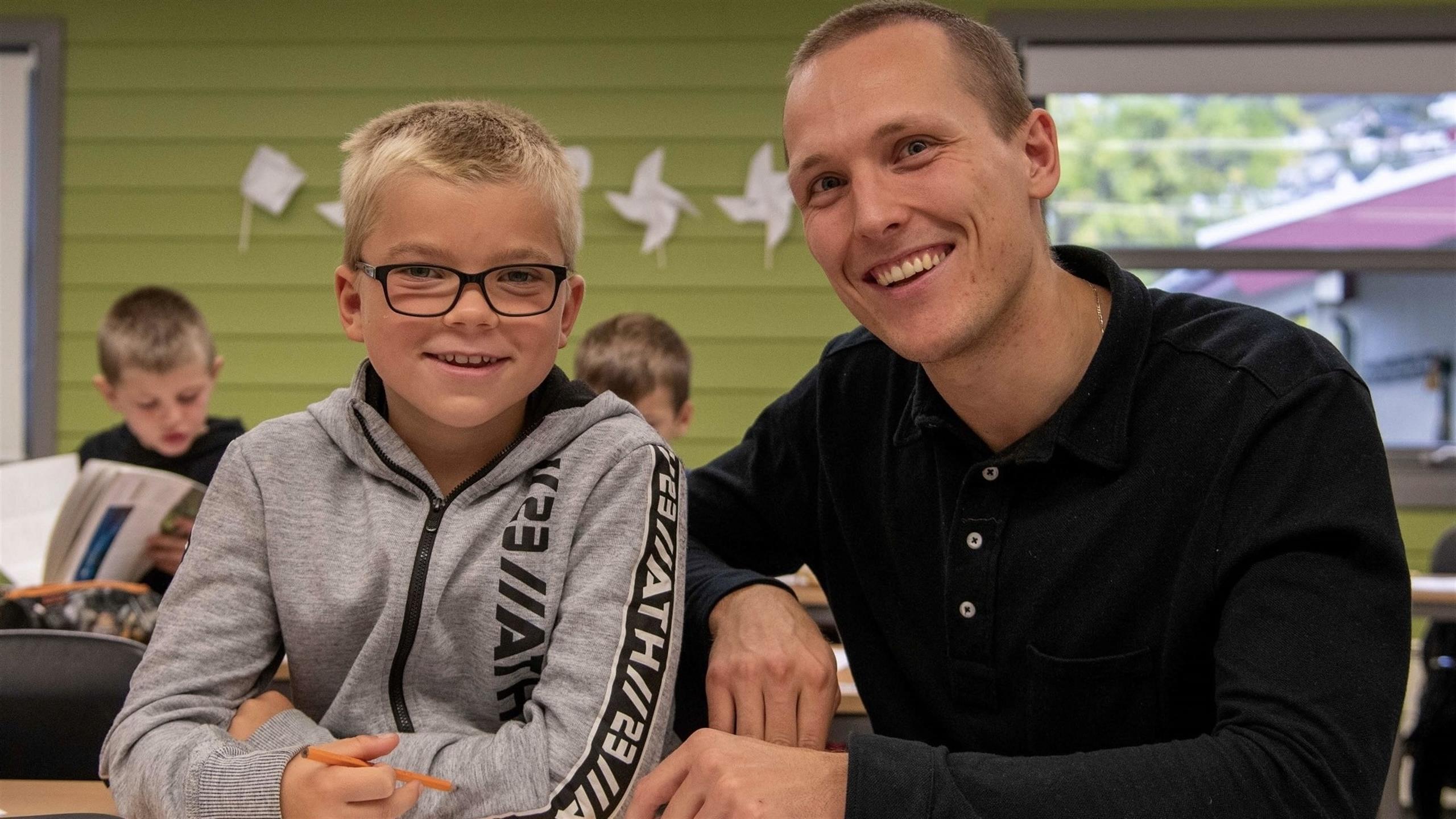 Student I praksis på barneskole saman med elev