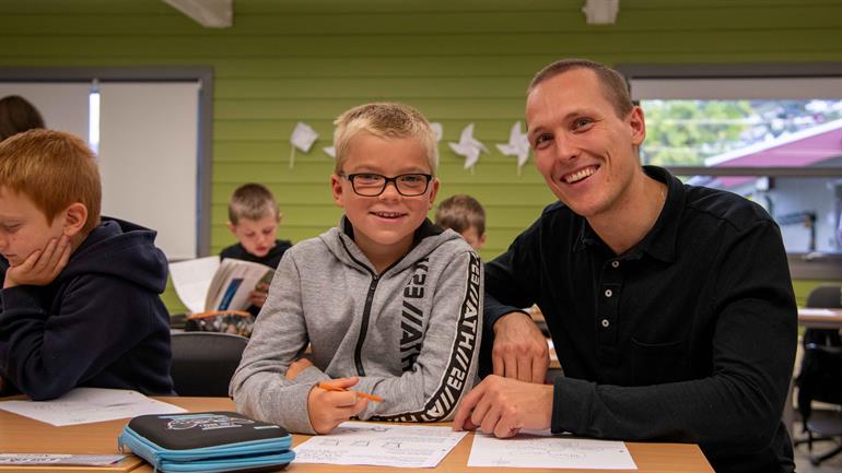 Student i praksis på barneskulen saman med elev.