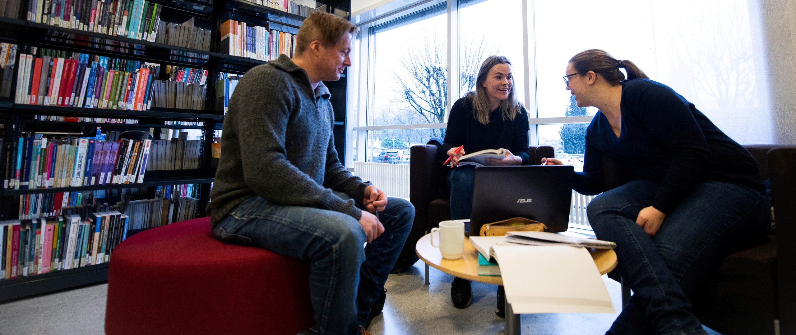 Tre studentar på biblioteket